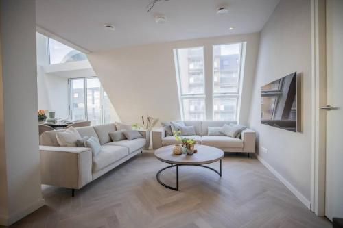 uma sala de estar com um sofá e uma mesa em Penthouse Royal, Luxurious and cozy with Sauna em Cadzand