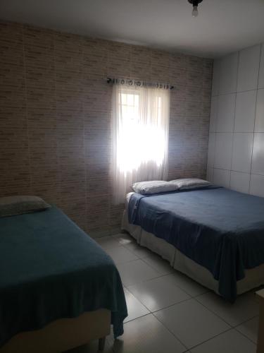 a bedroom with two beds and a window at Hotel Ouro Preto in João Pessoa