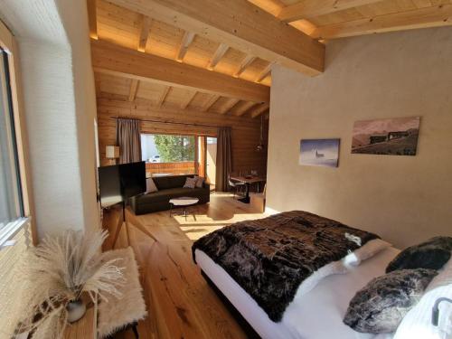 een slaapkamer met een bed en een woonkamer bij Die Holzgauerin in Holzgau