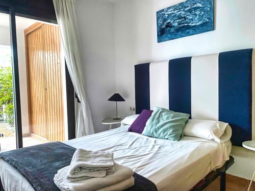 a bedroom with a bed with blue and white stripes at Casa Indalo - Resort Macenas Mojacar in Mojácar