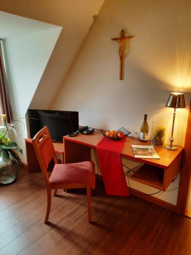 een kamer met een bureau met een kruis aan de muur bij Gästehaus Klosterhof Schweiklberg in Vilshofen an der Donau