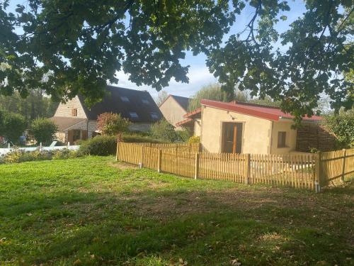 a house with a wooden fence in a yard at Gîte du Gué Maraud in Magny-Lormes