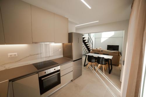 a kitchen with white cabinets and a dining room at Athens Heart Luxury Apartment in Athens