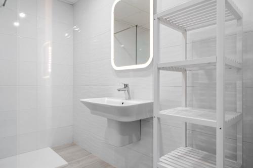 Baño blanco con lavabo y espejo en Gregal by enjoy Rocas Doradas en L'Ametlla de Mar