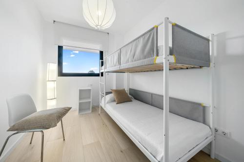 Dormitorio pequeño con litera y silla en Gregal by enjoy Rocas Doradas, en L'Ametlla de Mar