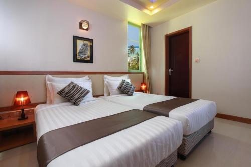 a hotel room with two beds in a room at Season Holidays at Hulhumale with Transfer in Hulhumale