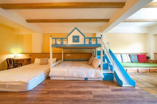 花蓮市的住宿－何家民宿，一间卧室设有两张双层床和滑梯
