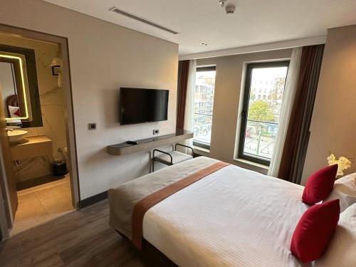 a hotel room with a bed and a flat screen tv at Edition Old City Hotel in Istanbul