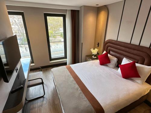 a bedroom with a large bed with red pillows at Edition Old City Hotel in Istanbul