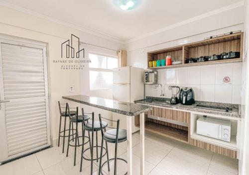 - une cuisine avec un comptoir et des tabourets dans l'établissement Caldas Novas, Hotel Lacqua diRoma 1,2,3,4 e 5, à Caldas Novas