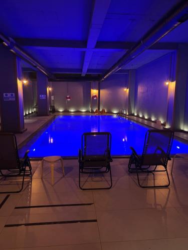 uma piscina com cadeiras e iluminação azul em Seyithan Palace Spa Hotel em Istambul
