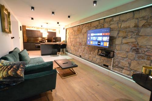 a living room with a couch and a stone wall at Apartament Gold in Złotoryja