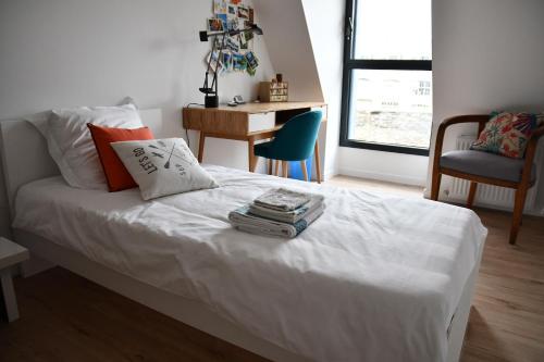 um quarto com uma cama branca, uma secretária e uma cadeira. em Le Beau Repaire 1 à 3 chambres étage indépendant em Angers