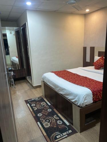 a bedroom with a bed and a bathroom with a mirror at Hotel hari palace in Jhānsi