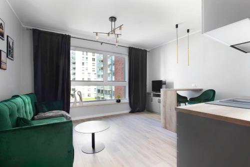 グダニスクにあるGolden Apartmentsのリビングルーム(緑のソファ、テーブル付)