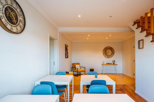 a room with tables and chairs and a clock on the wall at Santa Clara Lisbon Rooms in Lisbon