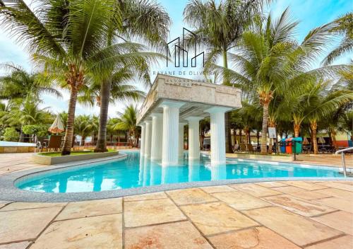 une piscine avec un panneau devant des palmiers dans l'établissement Caldas Novas, Hotel Lacqua diRoma 1,2,3,4 e 5, à Caldas Novas