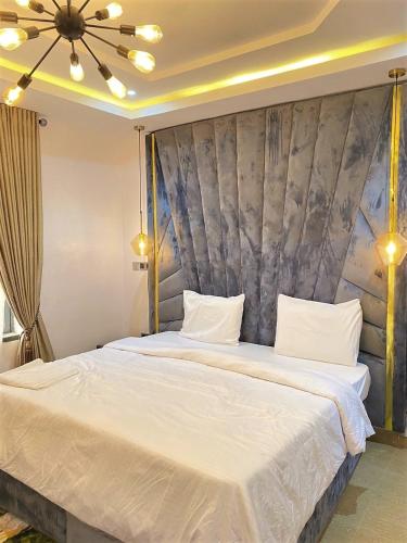 ein Schlafzimmer mit einem großen Bett mit weißer Bettwäsche in der Unterkunft 3 Bedroom Luxury Apartment in Lekki in Lagos