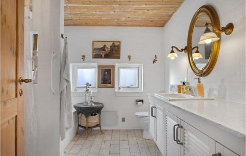 ein Badezimmer mit einem Waschbecken, einem WC und einem Spiegel in der Unterkunft Amazing Home In Skagen With Wifi in Skagen