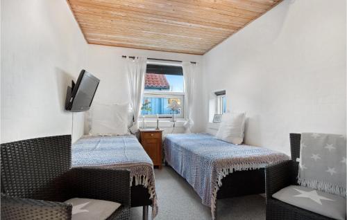 1 Schlafzimmer mit 2 Betten, einem TV und einem Stuhl in der Unterkunft Amazing Home In Skagen With Wifi in Skagen