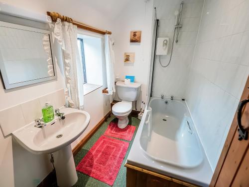 een badkamer met een wastafel, een toilet en een bad bij Cedar Cottage - Rchp132 in Calton