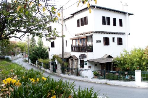 un edificio blanco al lado de una calle en Guesthouse Filokalia, en Portaria