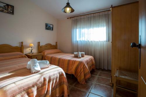 a hotel room with two beds and a window at Villa Parets de Sucre in Les Cases d'Alcanar