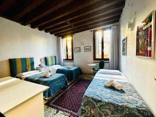 ヴェネツィアにあるGrimaldi Apartments Cannaregioのベッド2台とキッチンが備わるホテルルームです。
