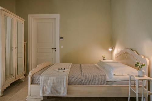 a bedroom with a white bed with a table at Villa Comi in Mavráta