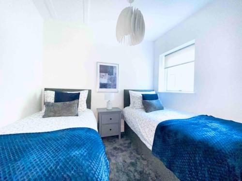 een slaapkamer met 2 bedden en een raam bij Exclusive 4-Bed House 10 minutes from Newcastle in Ravensworth