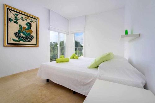 une chambre blanche avec deux lits et une fenêtre dans l'établissement Casa Laila - acceso directo al mar, piscina y wifi, à Portopetro