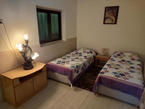1 dormitorio con 2 camas, mesa y ventana en Villa Cana, en Kafr Kannā
