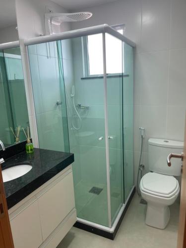 a bathroom with a glass shower and a toilet at Temporada Cabo Frio - Braga in Cabo Frio