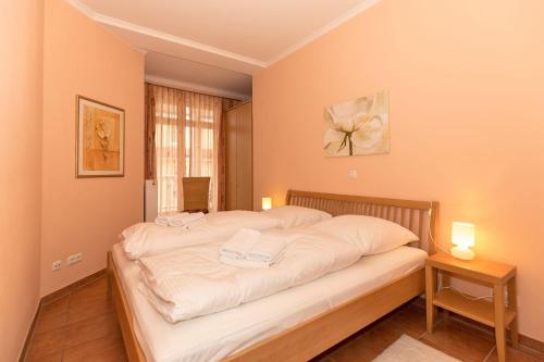 a bedroom with a large bed with white sheets at Duenenschloss-Haus-1-Wohnung-12-487 in Kühlungsborn