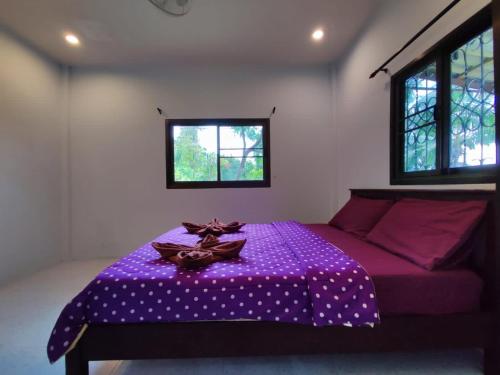 Chalisa Bukit House Lanta في Ban Mo Nae: سرير أرجواني فوقه وعاء