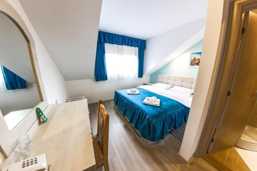 Habitación pequeña con cama y mesa en Hotel Ravni Gaj, en Knić