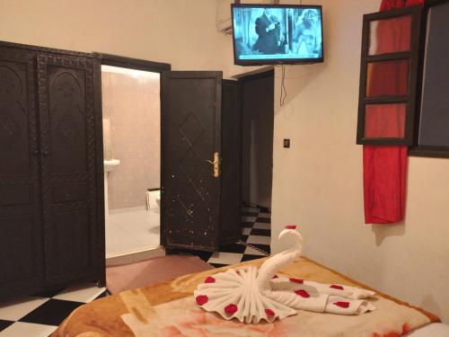 um quarto com uma televisão e um frango numa cama em Hôtel Agnaou em Marrakech