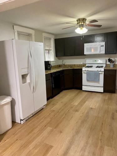 a kitchen with a white refrigerator and wooden floors at Lincoln Park Apartment with Backyard! in Chicago