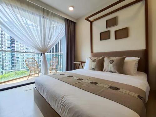 a bedroom with a large bed and a large window at Timurbay Seafront Residences by Nature Home in Kuantan