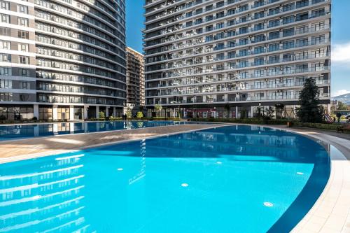 an empty swimming pool in front of two tall buildings at The Grandeur Hotel in Batumi