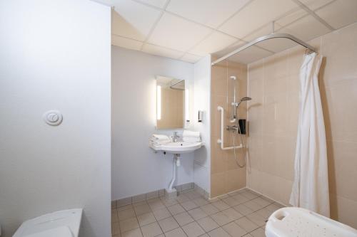 a bathroom with a sink and a toilet and a shower at B&B HOTEL Lille Grand Stade in Villeneuve d'Ascq