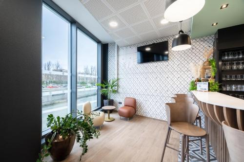 a bar in a restaurant with plants at B&B HOTEL Lille Grand Stade in Villeneuve d'Ascq