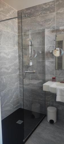 a bathroom with a shower and a sink at Hotel Uhainak in Hendaye