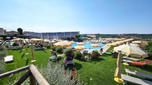 Blick auf einen Pool mit Sonnenschirmen und Stühlen in der Unterkunft Morobello in San Marcello
