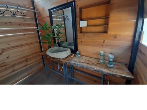 a bathroom with a mirror and a wooden wall at Cabañas o habitación en Fundo Huabayor in Lima