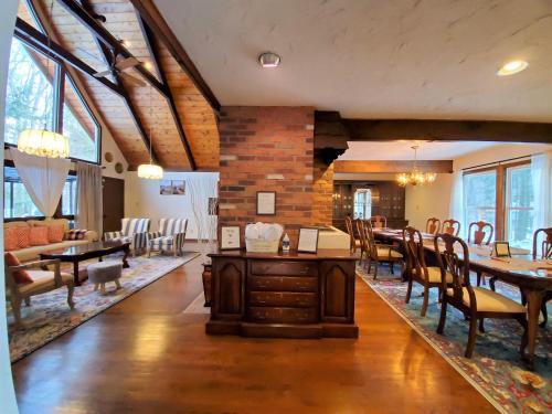 a dining room with tables and chairs and a brick wall at 1 Minute to Pool & Beach, Spacious Getaway, AC, Hot tub, Game room in Pocono Country Place