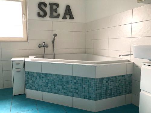 a bath tub in a bathroom with a tile floor at Kavelweg Haus JENNY in Zingst