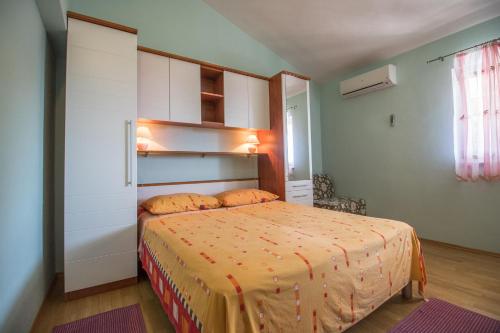 1 dormitorio con 1 cama con colcha de color naranja en Apartment Zdravka, en Kutleša