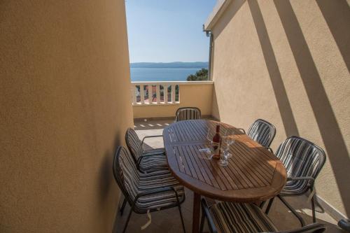 una mesa y sillas en un balcón con vistas al océano en Apartment Zdravka, en Kutleša