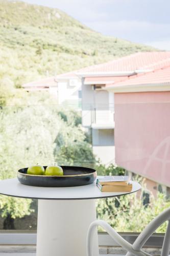 a bowl of green apples on a table in front of a window at Racconto Boutique Design Hotel (Adults Only) in Parga